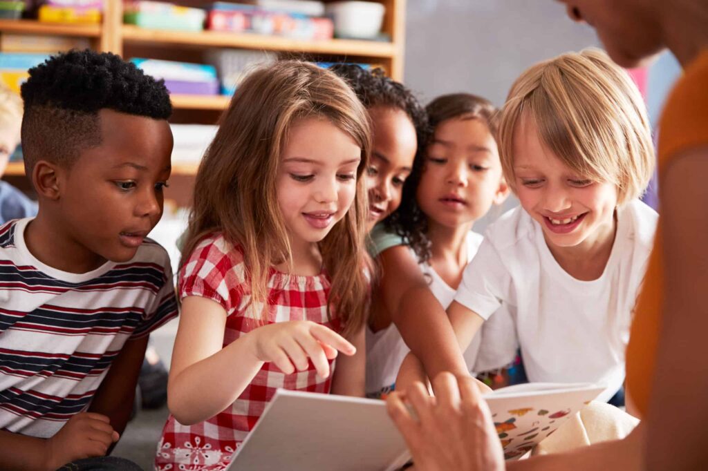Elementary school children sitting reading book